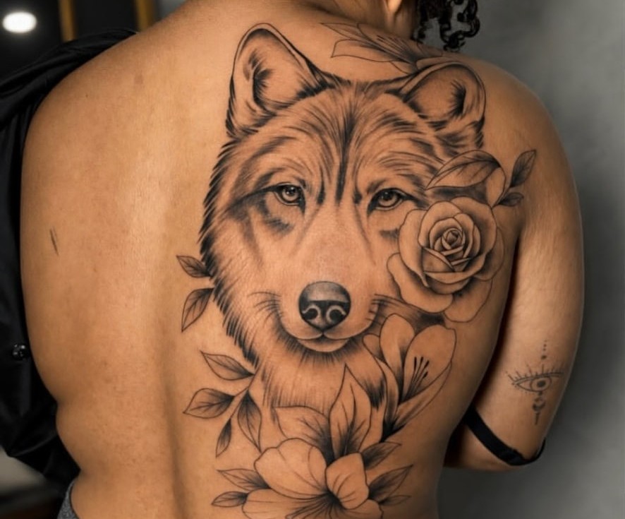 Tatuagem de lobo com flores em fine line e realismo